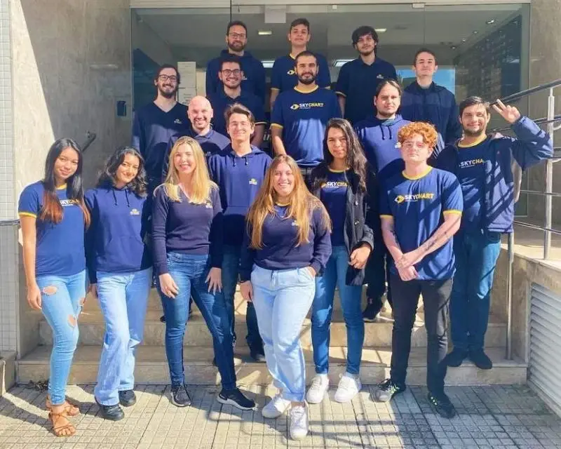 Equipe da Skychart WebSoftwares reunida na escada da empresa, de uniforme azul